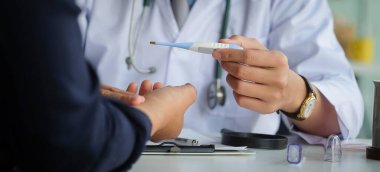Bir erkek hastaya sağlık sorunlarını açıklayan doktor.