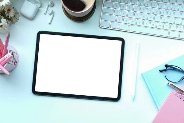 Dijital tablet, stilus kalem ve kahve fincanı ile beyaz masanın üstünde görünüm tasarımcısı çalışma alanı.