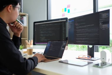 Asian man programmer working at at modern office. Developing programming.	