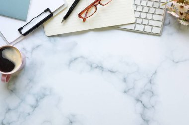 Kahve fincanı, gözlük, not defteri ve mermer masa üzerindeki pano ile üst görünüm stil çalışma alanı.