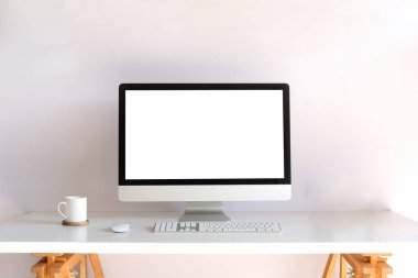 Boş ekran ve beyaz masada kahve fincanı olan ön görünüm bilgisayarı.
