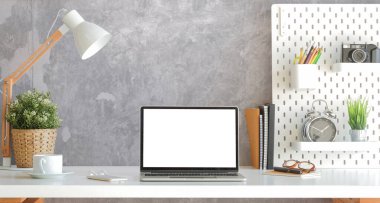 Modern işyeri, bilgisayar dizüstü bilgisayar ve malzemeler beton duvarlı beyaz masada..