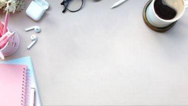 Kahve, bardak, kulaklık ve defterden oluşan basit çalışma alanı.