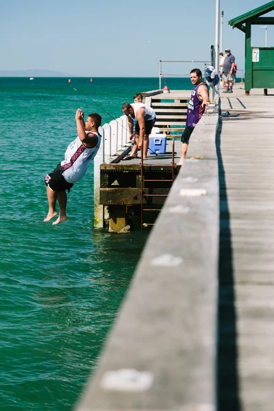 Junge Männer springen von Steg ins Wasser — Stockfoto