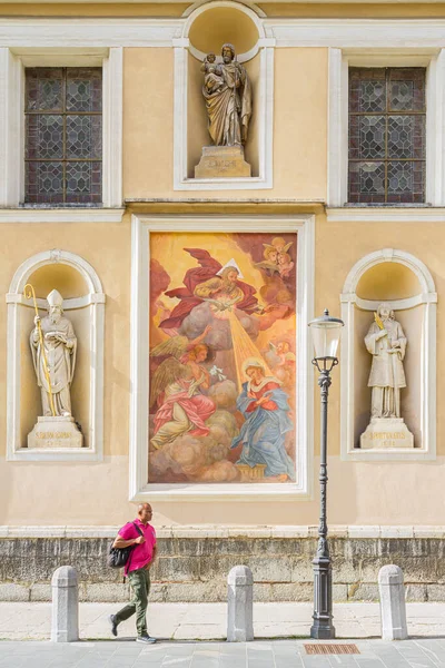Ljubljana, Slovenya - 15 Ağustos 2018: Ljubljana Katedrali veya St. Nicholas Kilisesi 'nin güney cephesindeki bazı sanat eserlerinin önünden geçen bir adam