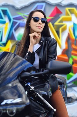 Motosiklette oturan şık bir esmer..