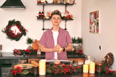 Genç bir adam mutfakta Noel için kurabiye hazırlıyor..