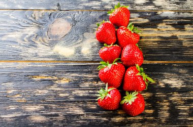 Koyu ahşap arka plan üzerinde çilek.