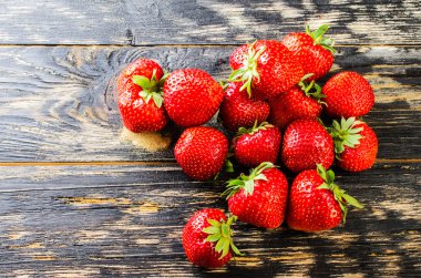 Koyu ahşap arka plan üzerinde çilek.