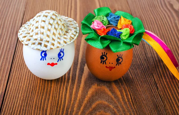 Funny eggs in the hat and wreath. — Stock Photo, Image