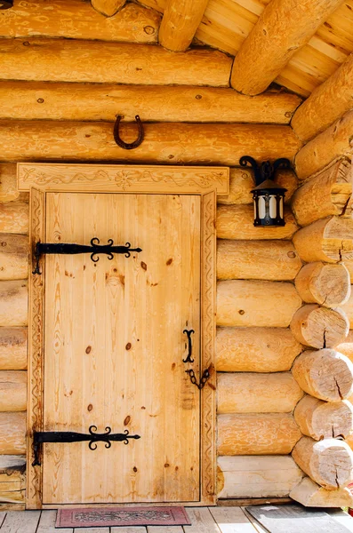 Doors with wrought iron hinges in the wooden house. — Stock Photo, Image