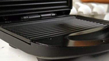 Kalın, yağlı sosisler elektrikli ızgarada kızartılır. Yakın plan..