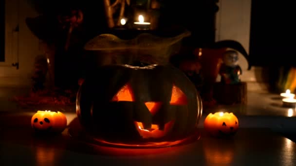 Decoración del hogar con espeluznantes resplandores halloween cabeza de calabaza Jack Lantern cara y vela ardiente. Ojos tallados, boca. Símbolo tradicional de Halloween. Primer plano. — Vídeos de Stock