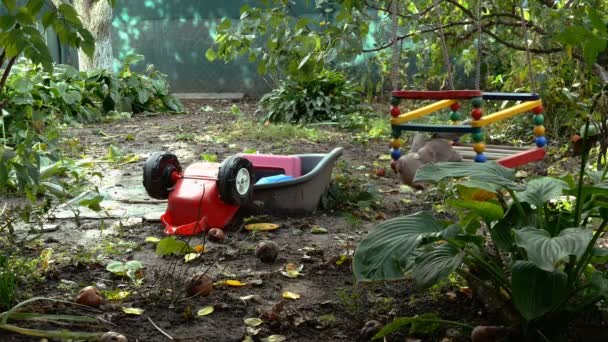 Gevuld speelgoed schommelend op schommel in de achtertuin op een lege speelplaats. Gebrek aan leven tijdens coronavirus quarantaine. Herfst uitzicht. Gele bladeren, verwelkende natuur. Middelmatig schot. — Stockvideo