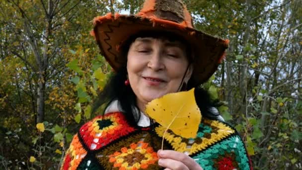 美しい明るい服のエレガントな成熟した大人の女性は秋の公園で感情的に話しています. — ストック動画
