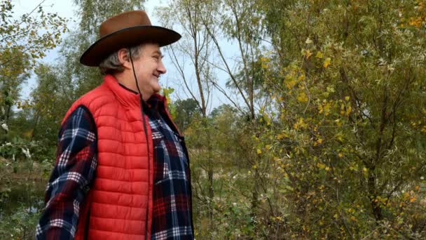 Un uomo in un parco autunnale. Elegante donna adulta matura in bei vestiti luminosi cammina verso di lui e si abbracciano teneramente. Concetto di felicità familiare. Primo piano. — Video Stock