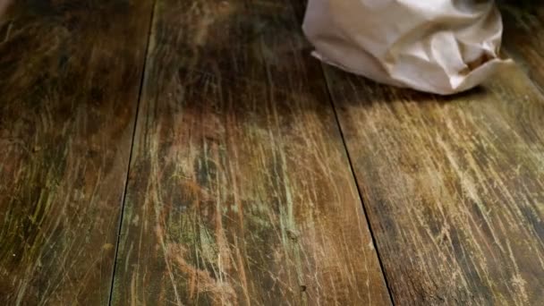 Lavori di cucina. Agrumi limone stanno gettando dal sacchetto di carta sul tavolo di legno. Primo piano. — Video Stock
