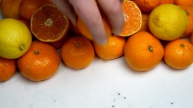 Bol miktarda C vitamini içeren narenciye, portakal ve limon yığını. Covid-19 Coronavirus 'la savaşmak için bir yığın sağlıklı meyve. İnsan eli, mandalina derisi. Yakın plan..