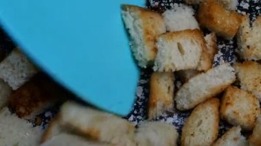 Beyaz ekmek dilimleri doğranmış, tavada kızartılmış ve kıtır ekmek yapmak için spatulayla çevrilmiş. Ev yapımı mutfak. Yakın plan..