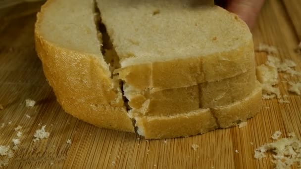 A fehér kenyérszeleteket konyhai késsel kockákba vágják, hogy krutont vagy keményet készítsenek a fa vágódeszkán. Házi készítésű konyha. Közelkép. — Stock videók