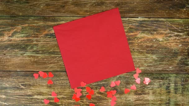 Le mani umane mettono la tazza di caffè e l'orsacchiotto sul tovagliolo rosso. Cuori rossi. Giornata romantica. Giorno di San Valentino o concetto di giorno delle donne. Vista dall'alto. Piatto. Primo piano. — Video Stock