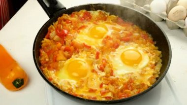 Şefin sebze soslu yumurtalı milk shuka 'sı kızartma tavasına hazırlanıyor. Yahudi ve Arap mutfağı. Shakshuka tarifi. Yemek pişirme süreci. Yakın plan..