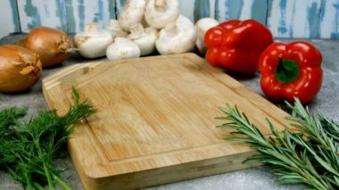 Ev mutfağı. Şef, et ya da barbekü ile sebze yemeği pişirmek için büyük çiğ domuz pirzolası parçalarını tahta kesme tahtasına koyar. Yakın plan. Yiyecek..