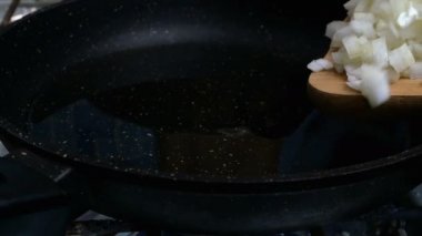 Çiğ büyük yenilebilir şampiyonlar, dört dilime bölünmüş soğanlar, kızartma tavasına eklenmiştir..