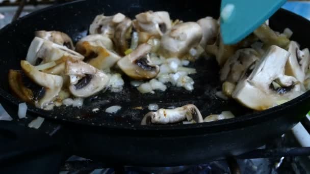 Surowe duże jadalne champignons, pokrojone w cztery plastry i drobno posiekane cebule, mieszając w patelni do gotowania i podejmowania pyszne jedzenie. Zbliżenie. — Wideo stockowe