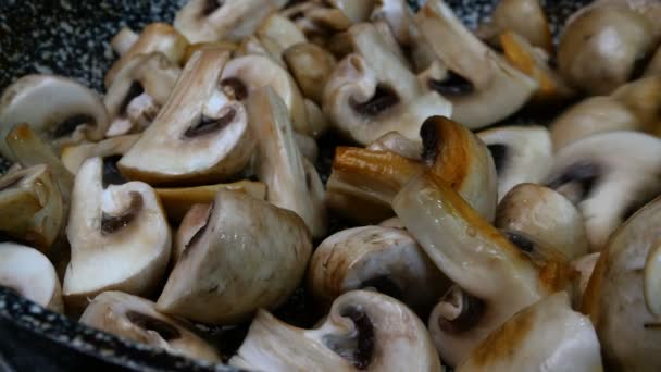 Grandi champignons crudi commestibili, tagliati a quattro fette mescolando in padella con spatola da cucina per cucinare e fare cibo delizioso. Primo piano. — Video Stock