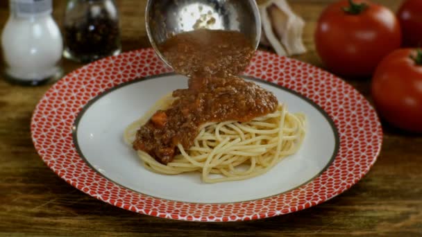 Болоньезе соус положить в приготовленные спагетти или Tagliatelle пасты в белой тарелке, в ресторане или домашней кухне. Посыпать пармезан. Домашний рецепт приготовления пищи. Крупный план. — стоковое видео