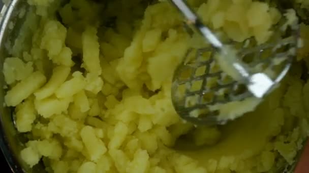 Processo de fazer purê de batatas com masher em panela de metal. Receita de cozinha caseira. Close-up. — Vídeo de Stock