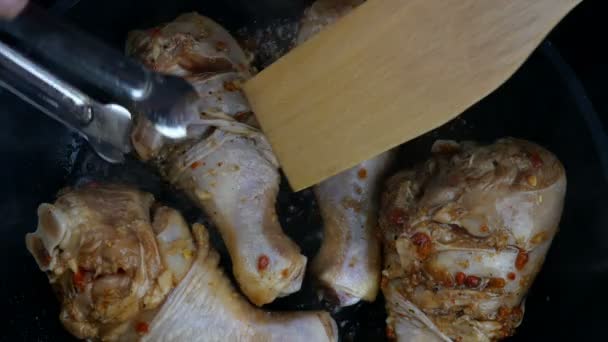 Sült csirkelábak olajban való sütésének folyamata serpenyőben. Finom, magas kalóriatartalmú étel. Házi főzés recept. Tetőtől talpig kaja, felülnézetből. Közelkép. — Stock videók