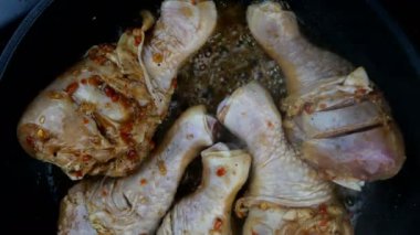 Kızartma tavasında kızarmış tavuk bacağı pişirme işlemi. Lezzetli yüksek kalorili yemekler. Ev yemeği tarifi. Yukarıdan aşağıya yemek, yukarıdan manzara. Yakın plan..