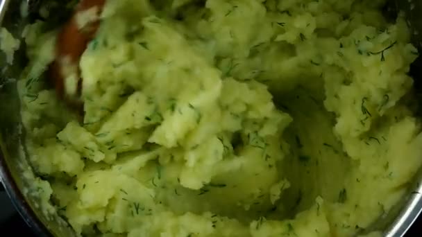 Purè di patate sono mescolati in pentola di metallo con cucchiaio di legno con burro e aneto. Ricetta di cucina casalinga. Primo piano. — Video Stock