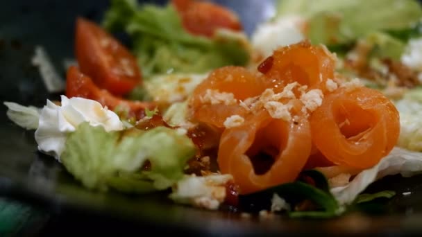 Ensalada fresca sabrosa con verduras, salmón salado y queso crema. Deliciosa comida mediterránea. Enfoque selectivo. Foco suave. Primer plano. — Vídeos de Stock