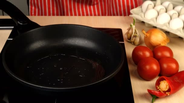 Verter el huevo de pollo en la sartén caliente y cocinar los huevos fritos. Tomates, pimienta y ajo. — Vídeos de Stock