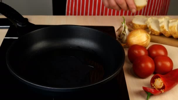 Cocinar pan crutones fritos en aceite vegetal en la cocina casera en una sartén en una estufa eléctrica. — Vídeo de stock
