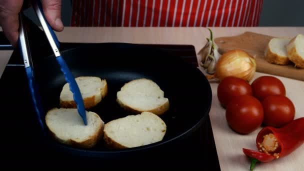 Cottura crostini di pane fritti in olio vegetale in cucina casalinga in padella su una stufa elettrica. — Video Stock