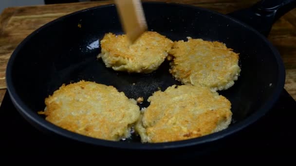 Toasted crispy crust golden potato pancakes or deruny fried in boiling oil in frying pan. Tasty draniki. Traditional european food. Domestic kitchen. Close-up. — Stock Video