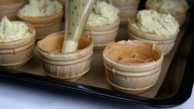 Şefin elleri lastik koruyucu eldivenlerle beyaz tavuk yumurtalarını karton yumurta tepsisinden alıp kahvaltı hazırlamak için kırar. Ev mutfağı. Yakın plan..