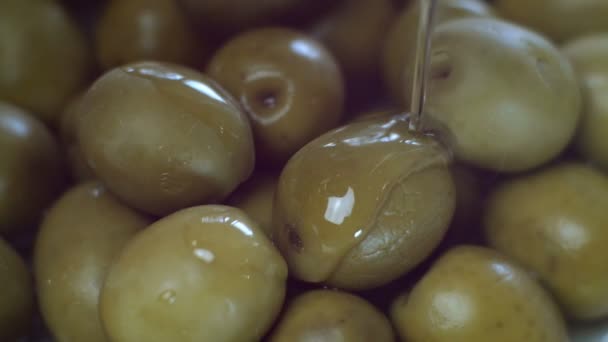 Verter aceite de oliva virgen extra orgánico dorado fresco sobre una pila de aceitunas verdes crudas de la botella. Aceitunas verdes sabrosas. Primer plano. — Vídeos de Stock