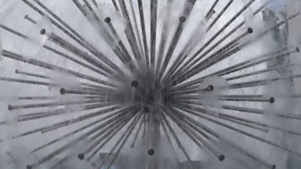 Ondas de agua transparente de los tubos en la fuente decorativa, girando en círculo, con salpicaduras durante el día. Primer plano. — Vídeo de stock
