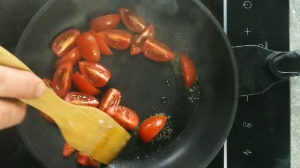 Preparación de huevos fritos con tomate en sartén para el desayuno en la cocina eléctrica en la cocina doméstica. Huevo de pollo crudo roto cae en sartén caliente. Vista superior. Comida de arriba abajo. Primer plano. — Vídeo de stock