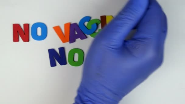 Die menschliche Hand faltet die Aufschrift No impfstoff no life aus bunten Buchstaben auf weißem Hintergrund. Konzept der Impfung als Rettung Ihres Lebens während der Coronavirus-Epidemie. Ampulle und Spritze. — Stockvideo