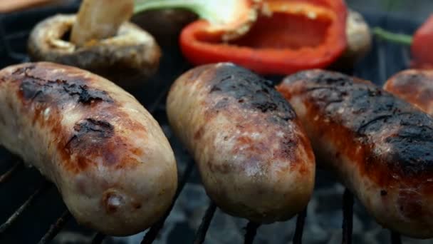 Friggere le salsicce bavaresi grasse cotte alla griglia o alla griglia. Con peperoni vegetali e funghi. Primo piano. — Video Stock