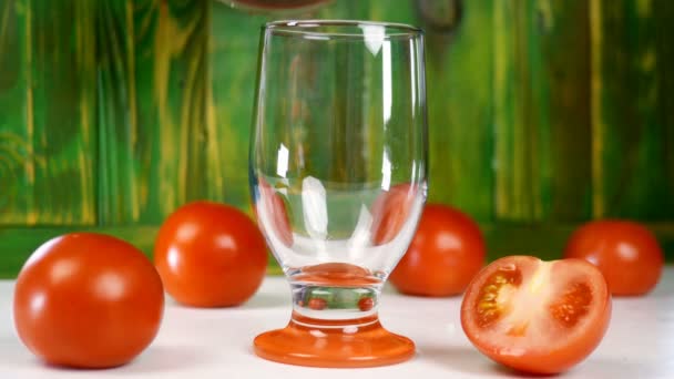 Frischen Tomatensaft in leeres, transparentes Glas gießen, daneben liegen frische reife natürliche Tomaten. Gesundes vegetarisches Getränk mit vielen Vitaminen. Selektiver Fokus. — Stockvideo