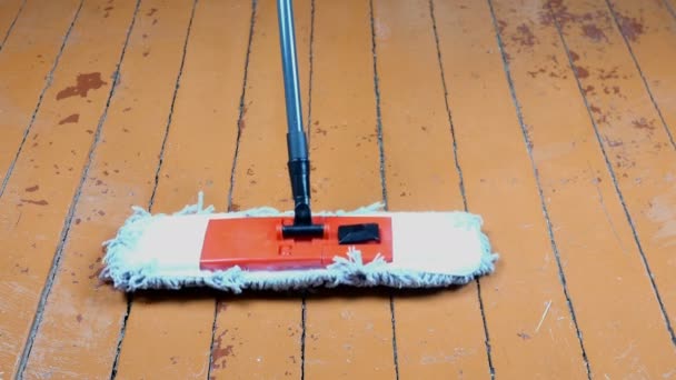 Zachte dweil schoonmaken en wast oude houten vloer in de kamer. Reiniging en ontsmetting. Routine huishoudelijk werk. De dweil beweegt op de vloer. Thuis opruimen. Close-up. — Stockvideo