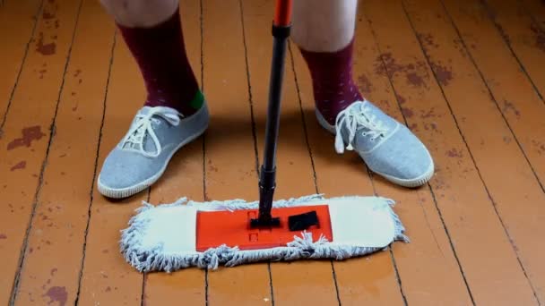 Fröhliche Männerfüße tanzen zu Hause mit Putzmopp beim Putzen und Waschen des Fußbodens. Spaß bei der Hausarbeit. Menschen Leben und Freude Konzept. Nahaufnahme. — Stockvideo