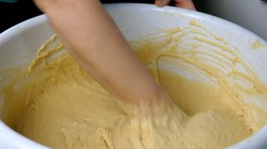 Ev mutfağında insan eli hamur yoğuruyor. Ev yapımı pişirme hazırlıkları için. Yakın plan..